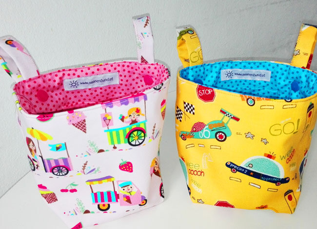 Zwei Pukwutzi-Taschen, links Eiswagen-Motiv, rechts Auto-Rennmotiv