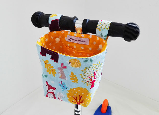 Pukwutzi-Tasche mit Waldtier-Motiv, am Lenker eines Kinder-Scooters